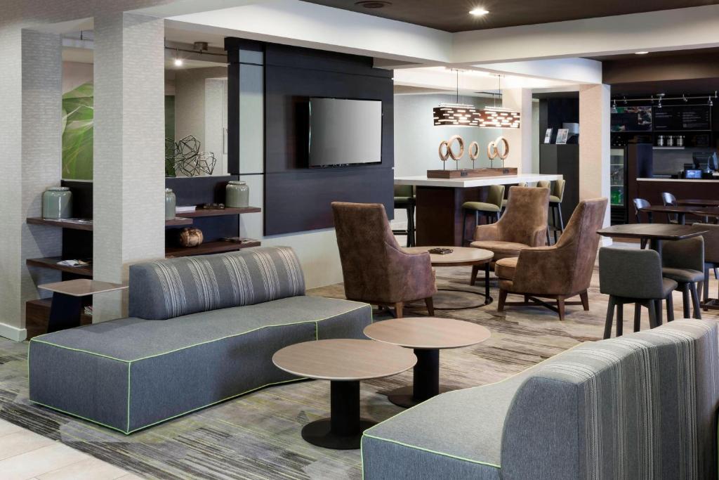 a lobby with a couch and tables and chairs at Courtyard Tuscaloosa in Tuscaloosa