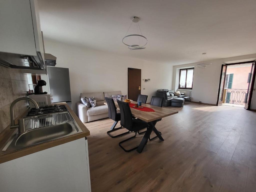 een keuken en een woonkamer met een tafel en een bank bij Sophia Apartment in Gravellona Toce