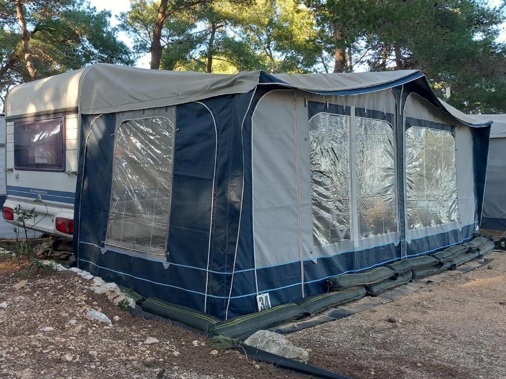 a tent is set up next to a trailer at Caravan near the sea 6 in Ugljan