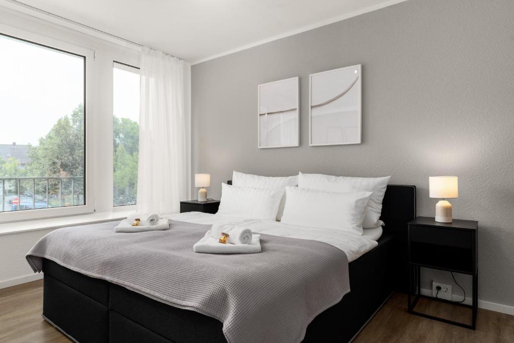 um quarto com uma cama grande com duas toalhas em SHINY HOMES - City Center with Parking Place em Gütersloh