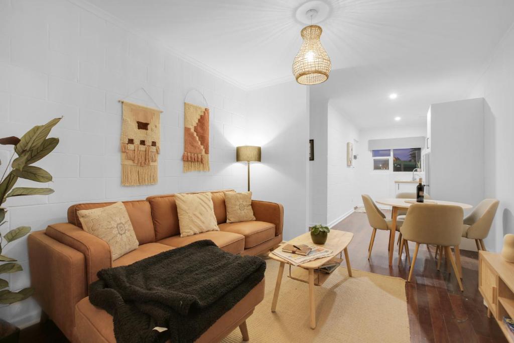 a living room with a couch and a table at Perfect Cosy Beachside Escape in Grange