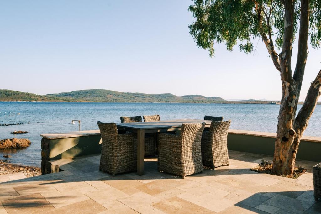 uma mesa e cadeiras com vista para a água em Unique Cunda Experience Stone House w Private Bay 
