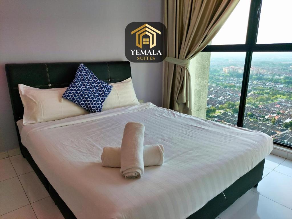 Una cama con una toalla en una habitación con ventana en Yemala Suites at Skyloft - Johor en Johor Bahru