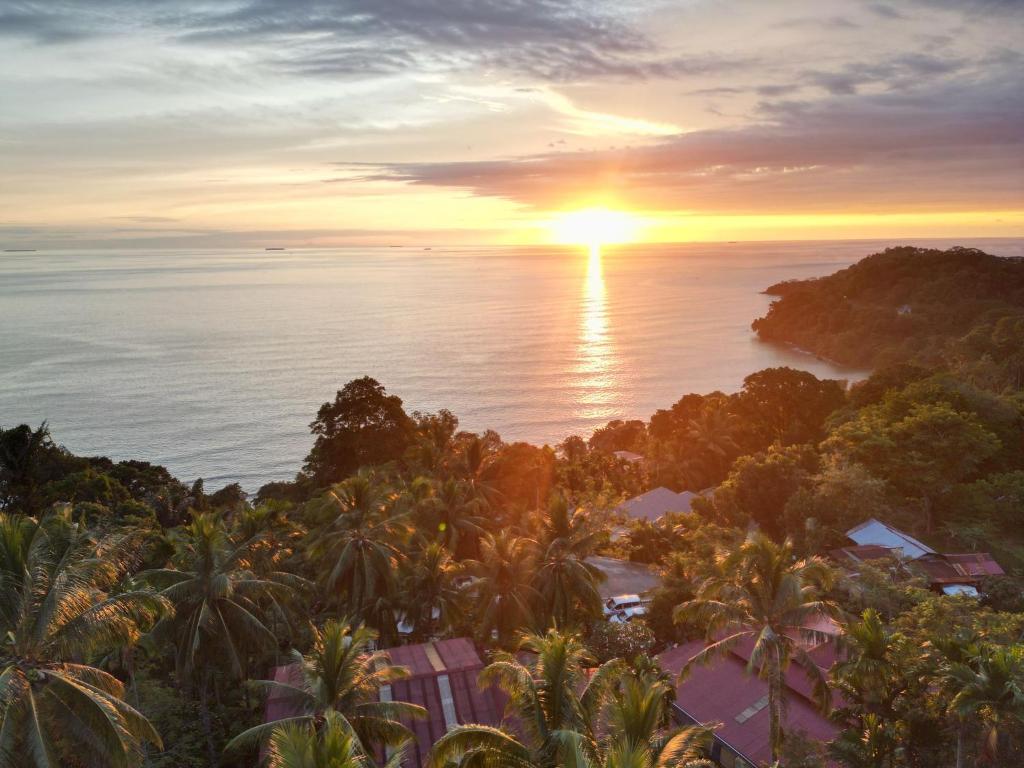 una vista aérea de una puesta de sol sobre el océano en Air Manis Hillside Villa Cafe & Resto, en Padang