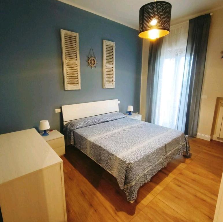 um quarto com uma cama e uma parede azul em Donata dal mare em Francavilla al Mare