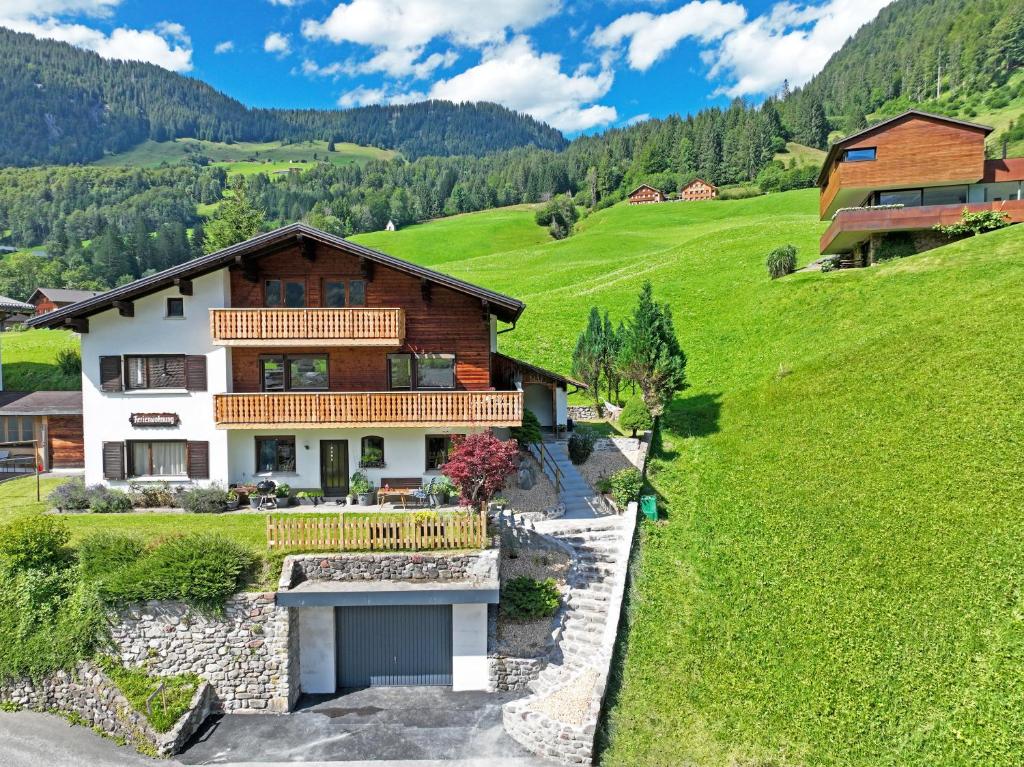 una casa in mezzo a una verde collina di Haus Theresia Rüf ad Au im Bregenzerwald
