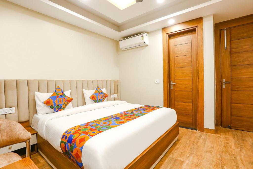een slaapkamer met een groot bed en een houten deur bij FabHotel Raahi Retreat in Gurgaon