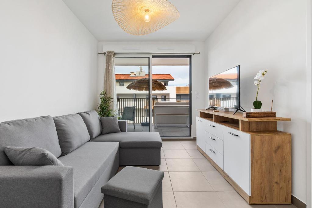 un salon avec un canapé et une table dans l'établissement Le Corinthe - Appt classé 3 étoiles et climatisé, à Marseillan