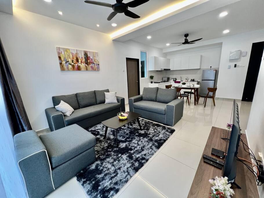 sala de estar con 2 sofás azules y cocina en Middle Town Breezy Stay {Novo8} 4pax-Wifi, en Melaka