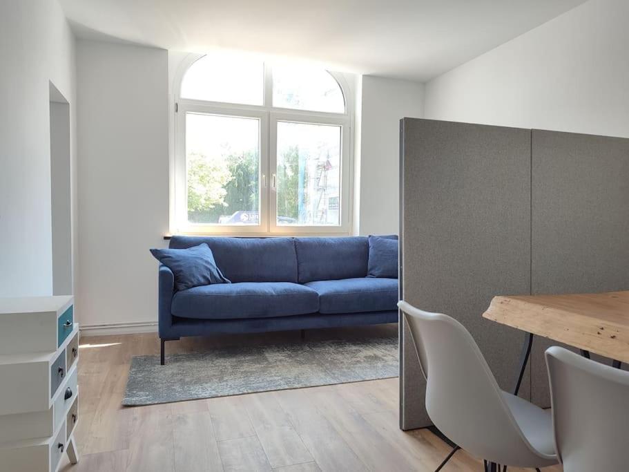 a living room with a blue couch and a table at 'BRIGHT 201' Moderne, helle Wohnung in BI Zentrum, 400 m bis Lokschuppen, Smart-TV, WLAN in Bielefeld