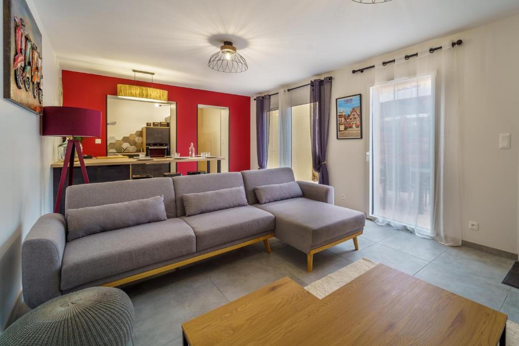 uma sala de estar com um sofá e uma mesa em Maison calme avec terrasse garage centre-ville B em Dijon