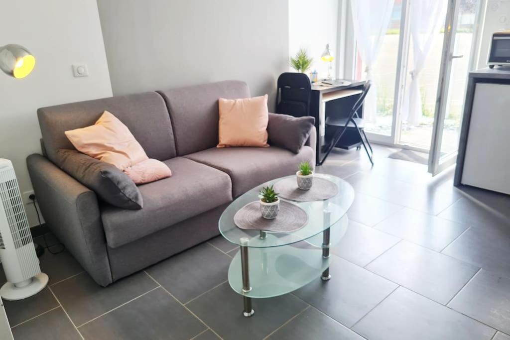 a living room with a couch and a glass table at studio neuf avec terrasse in Audincourt