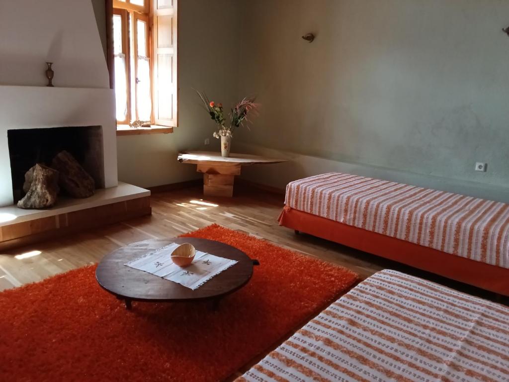 uma sala de estar com uma mesa, uma cama e uma lareira em Penelope Elafotopos em Elafotopos