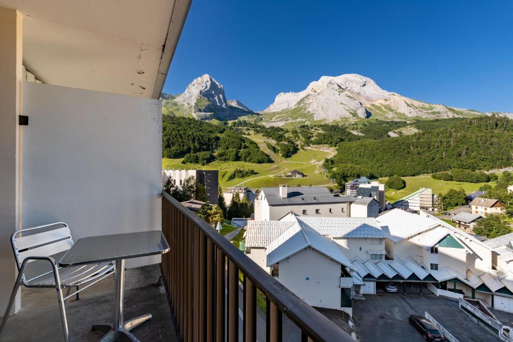 a chair on a balcony with mountains in the background at L'Esperta - Studio proche station de ski et ESF in Eaux-Bonnes