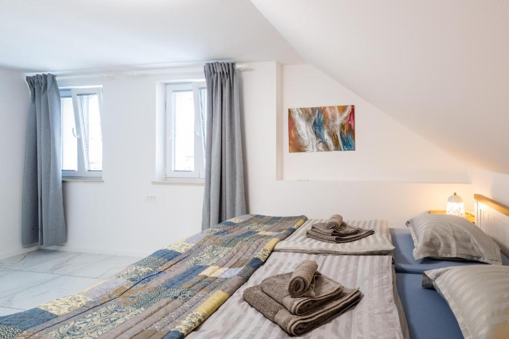 a bedroom with two beds with towels on them at Aparthouse Jana Breg in Žirovnica