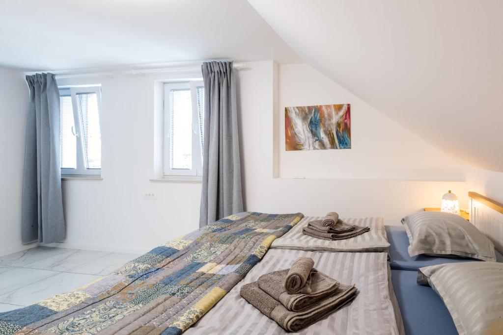 1 dormitorio con 2 camas y toallas. en Aparthouse Jana Breg, en Žirovnica
