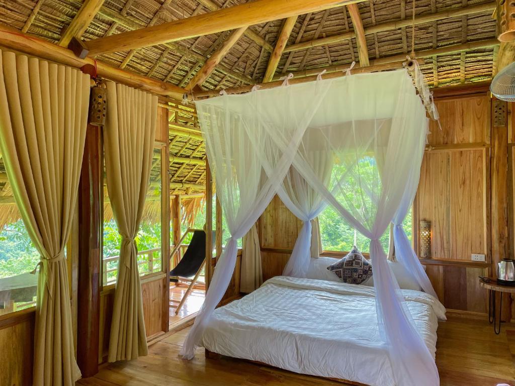 a bedroom with a canopy bed in a house at Pu Luong - Duy Phuong Homestay in Thanh Hóa