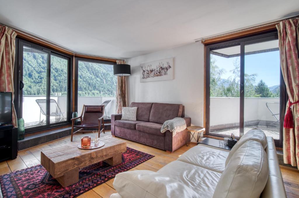 uma sala de estar com um sofá e uma mesa em Appartement Grand Beau Site By C2J em Chamonix-Mont-Blanc