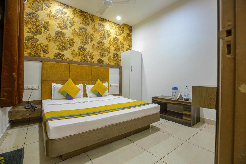 a bedroom with a bed with a yellow wall at HOTEL LIME WOOD in Ludhiana
