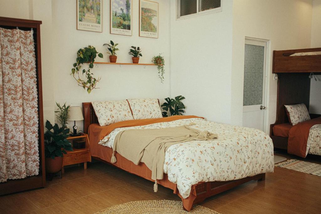 a bedroom with a bed and plants on the wall at Art Garden Dalat in Da Lat