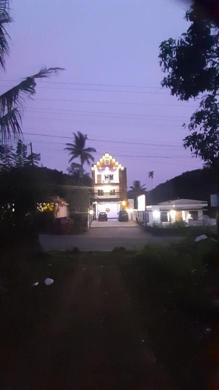 un edificio con un letrero iluminado por la noche en Himadri munnar holidays, en Munnar