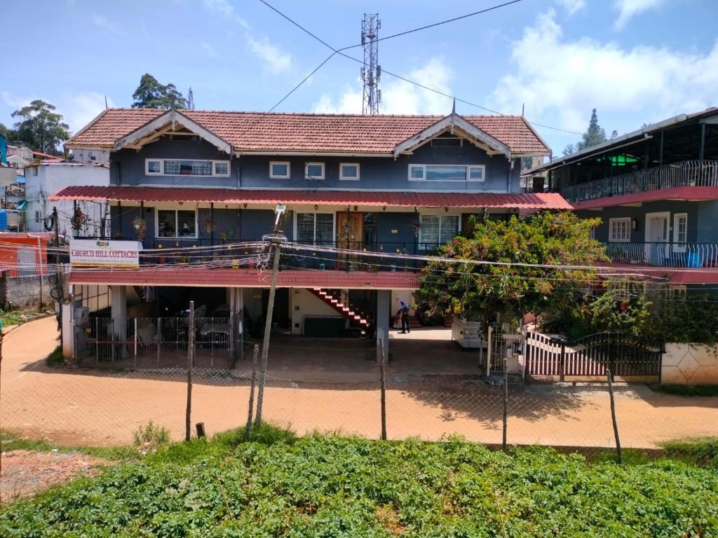 a large house with a red roof at Church Hill Cottage in Ooty