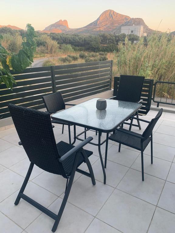 una mesa de patio y sillas con vistas a las montañas en Eucalyptοs house, en Lefkogeia