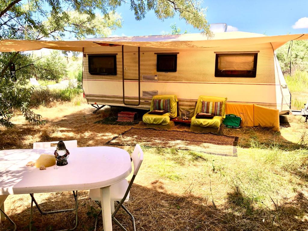 a campsite with a table and a caravan at Caravan on the beach, pet friendly in Corbu
