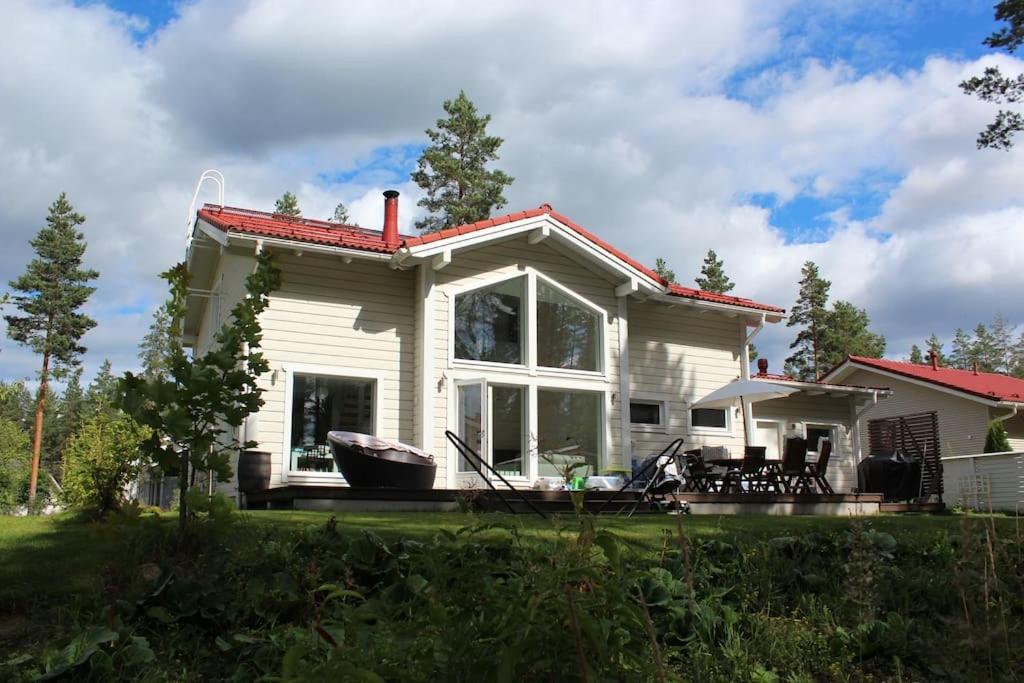 uma pequena casa branca com uma grande janela em Omakotitalo Vierumäellä X A house near Vierumäki sports center em Heinola