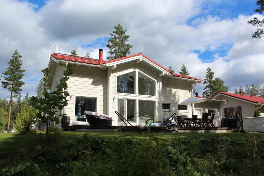 a small white house with a large window at Omakotitalo Vierumäellä X A house near Vierumäki sports center in Heinola