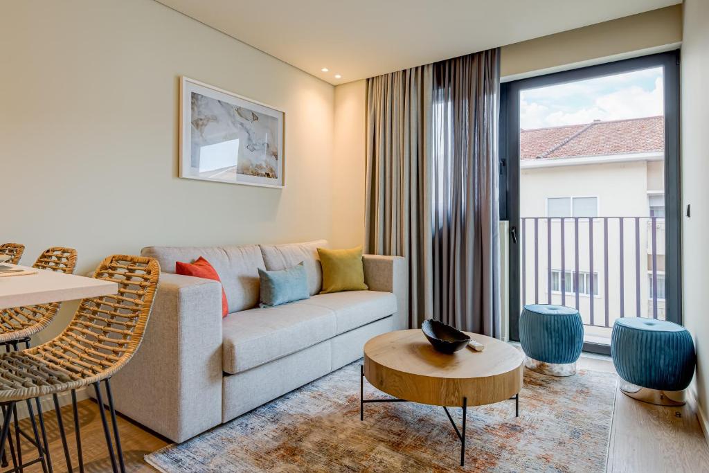 a living room with a couch and a table at Blissful Suites Porto in Porto