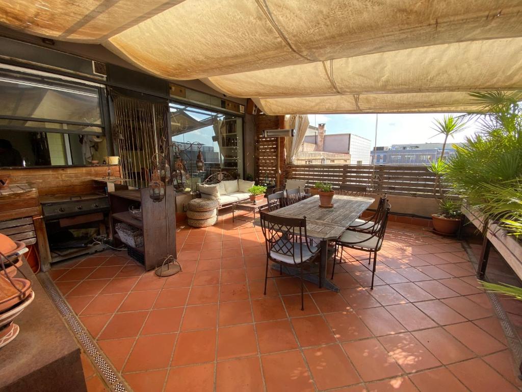un patio con tavolo e sedie sul balcone. di Casa con vistas a Barcellona