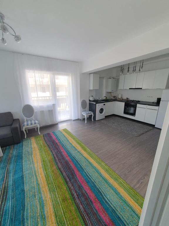 a living room with a colorful rug and a kitchen at meda's apartament in Floreşti