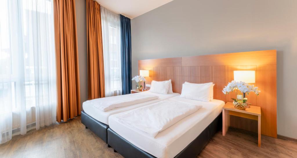 Schlafzimmer mit einem großen Bett mit einem Kopfteil aus Holz in der Unterkunft PLAZA Premium Köln in Köln