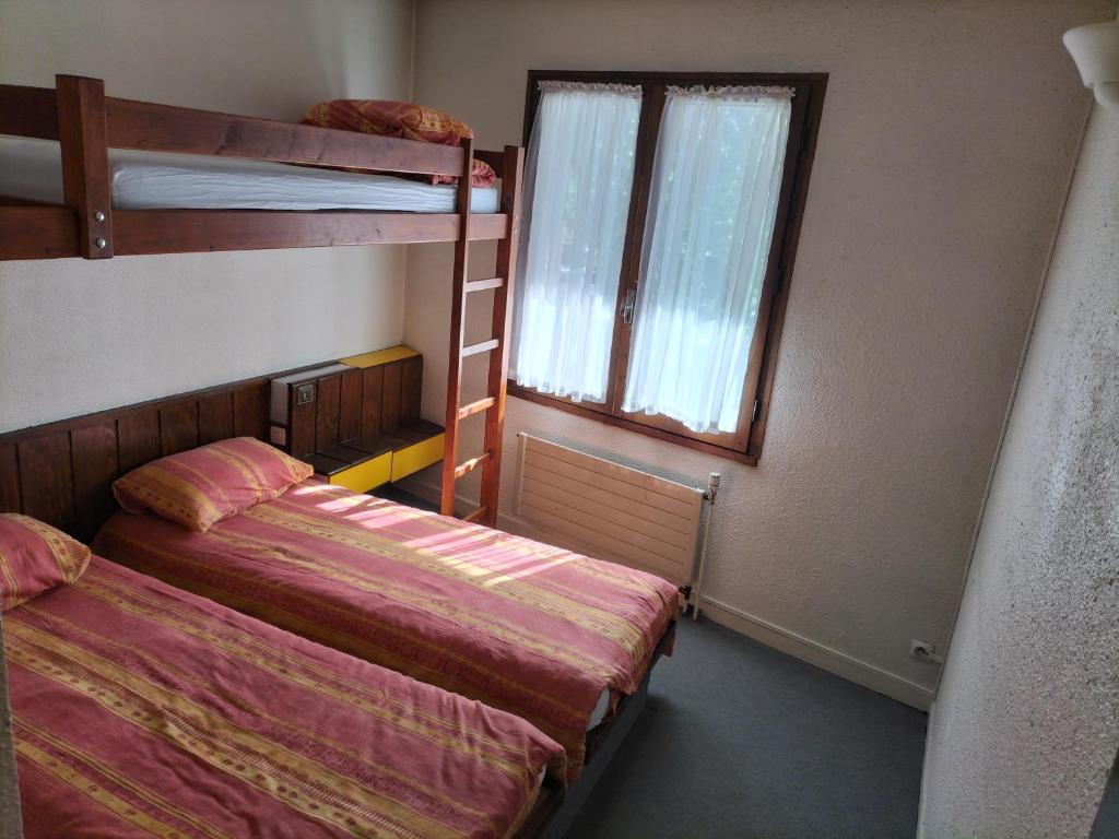 a bedroom with two bunk beds and a window at Chambre Triple avec Salle de Bains Privative 2 in Vallouise