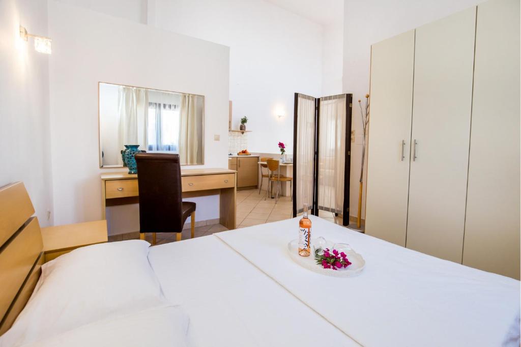 a bedroom with a bed and a desk and a table at PELAGO BUNGALOWS in Skala Potamias