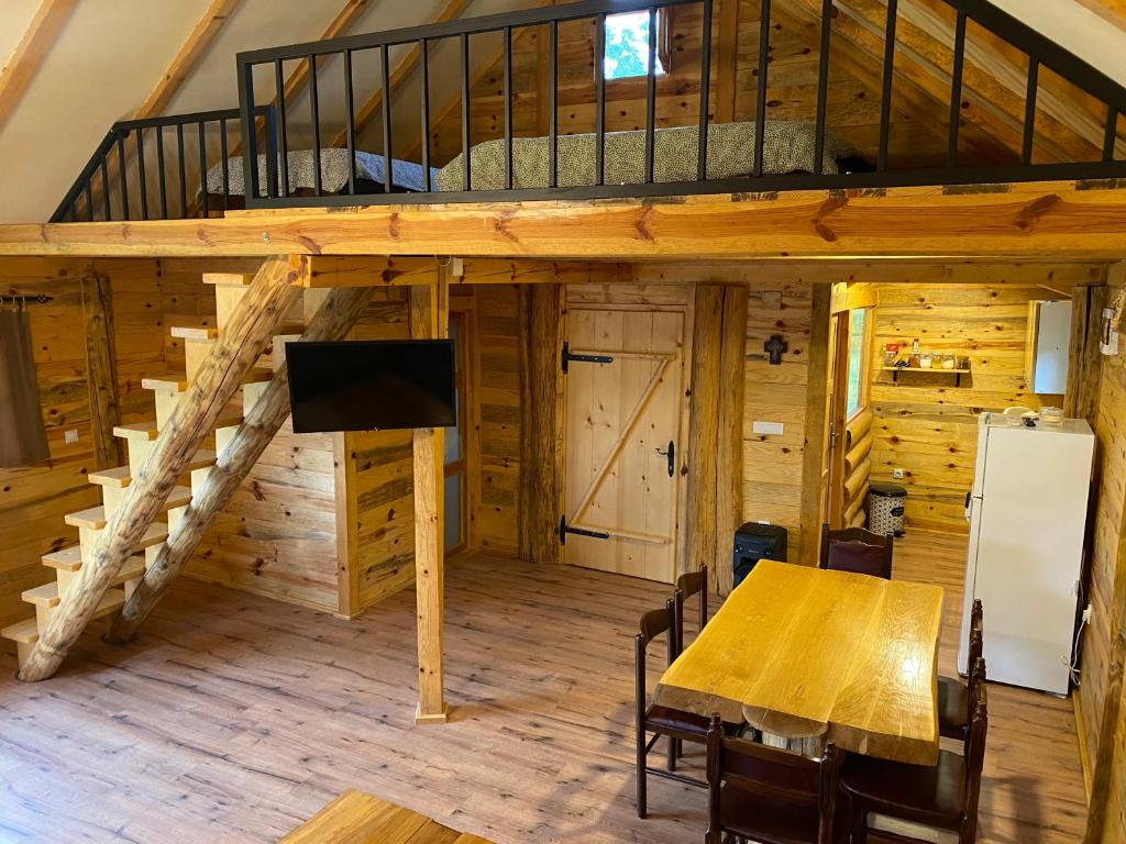 a room with a dining table and a loft at Vikendica Milošević in Arandelovac