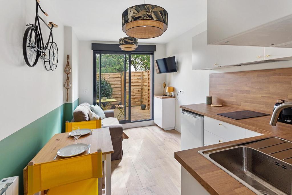 a kitchen and living room with a table and a sink at Loft des bords de Loire, idéal voyage d'affaires & Week end in Saint-Sébastien-sur-Loire