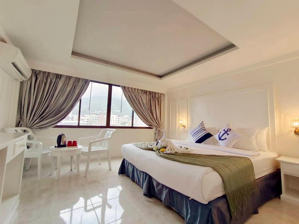 una habitación de hotel con una cama grande y una mesa en The Chilli Patong Beach Hotel - Near to the Beach -Completed Fully renovate 2023, en Patong Beach