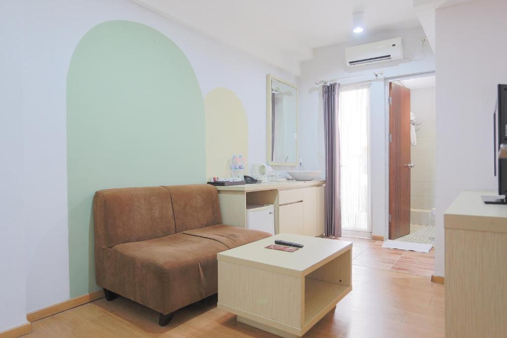 فندق غوناوانغسا مانيار في سورابايا: غرفة معيشة مع أريكة وطاولة