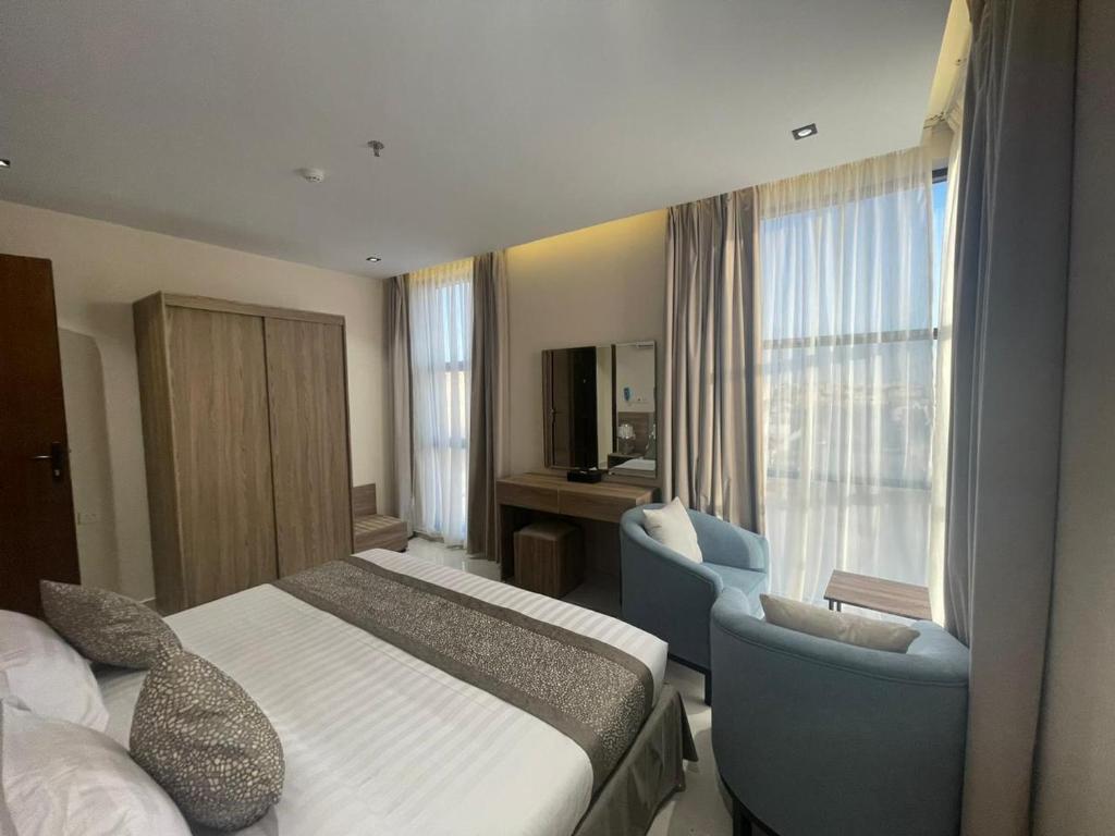 a hotel room with a bed and a chair and window at HIGH VIEW HOTEL فندق عالية الاطلالة in Hafr Al Baten