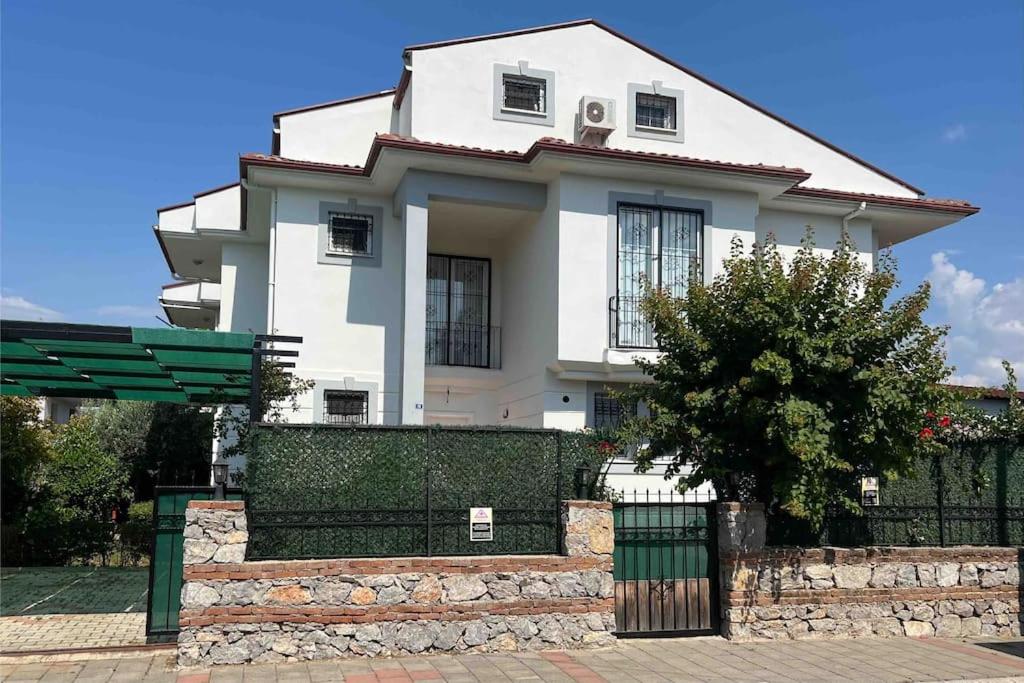 een wit huis met een hek ervoor bij Villa Melissa Fethiye in Fethiye