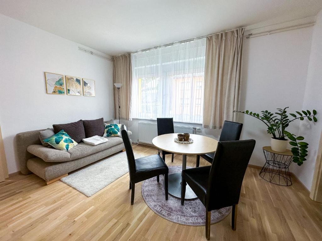 uma sala de estar com uma mesa e um sofá em Wohnung zum Wohlfühlen! em Feldbach