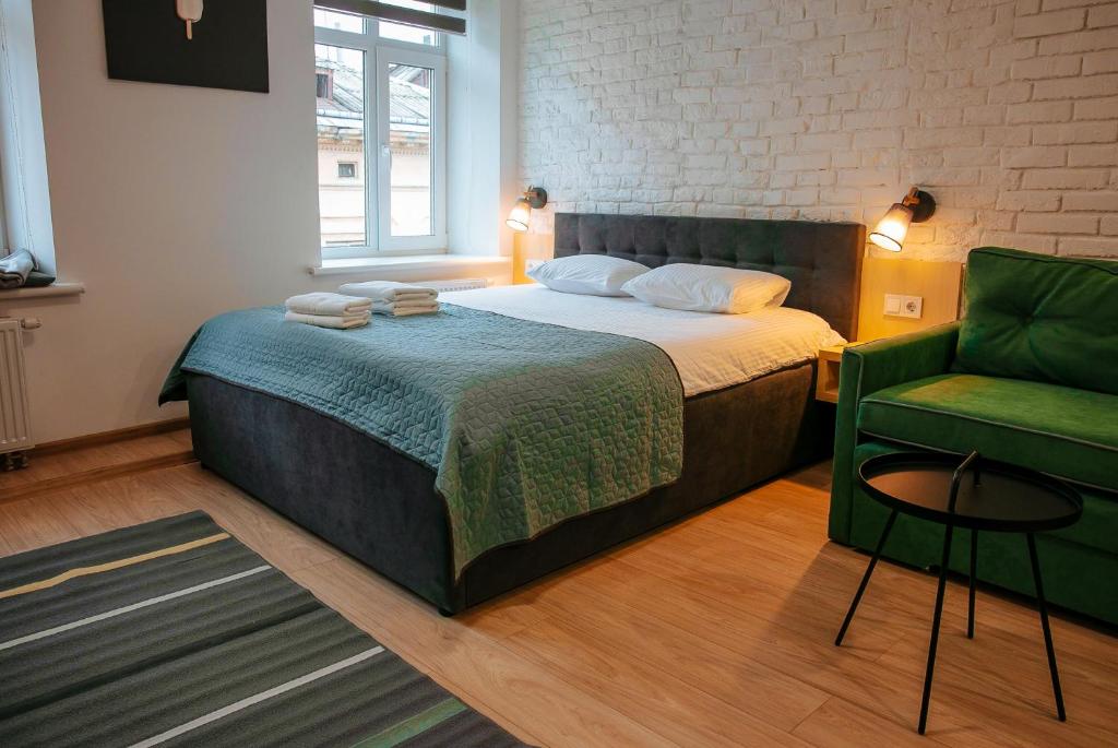 ein Schlafzimmer mit einem Bett und einem grünen Stuhl in der Unterkunft Apart Ivana Fedorova 30 in Lwiw