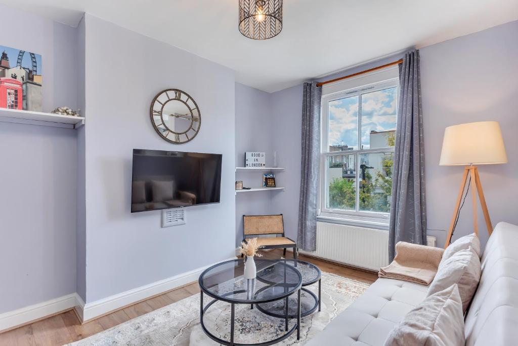 a living room with a couch and a tv at Aryas Apartments London in London