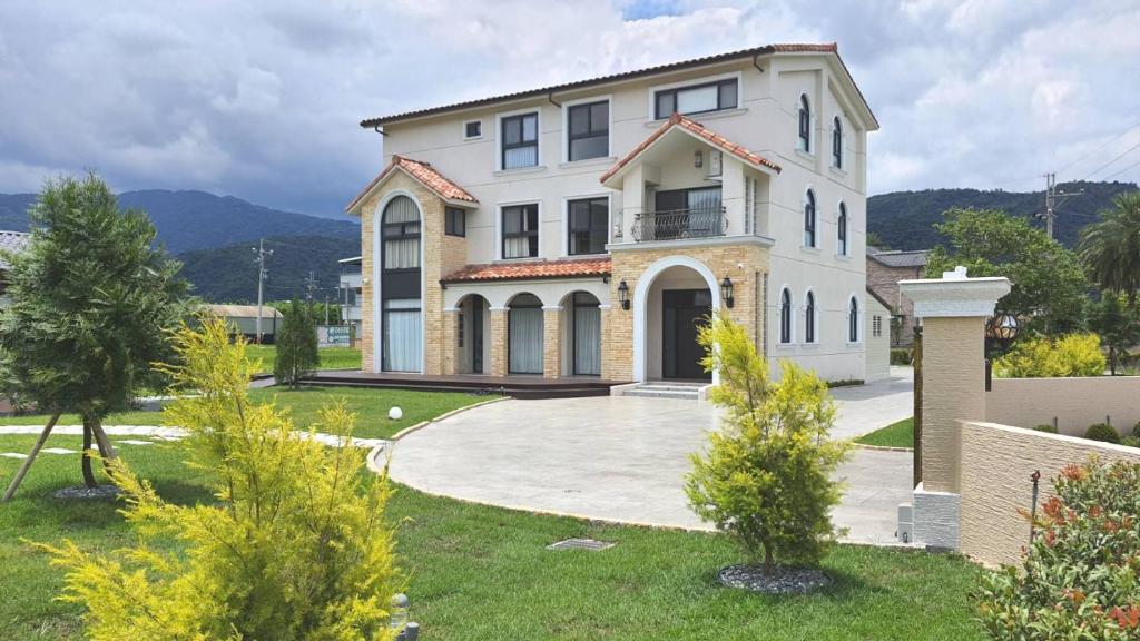 a large white house with a large driveway at 50 Lan House in Yilan City