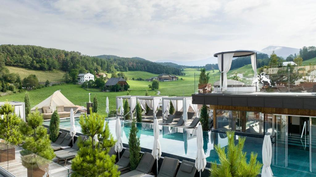 un hôtel avec une piscine et un complexe dans l'établissement ABINEA Dolomiti Romantic SPA, à Castelrotto