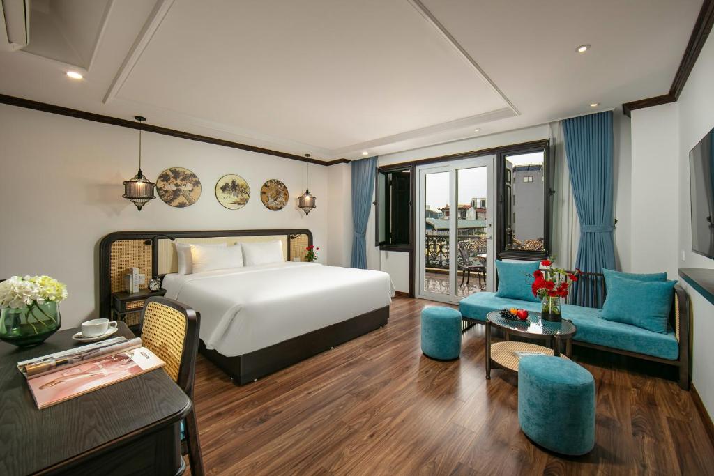 a hotel room with a bed and a table and chairs at Media Central Hotel & Spa in Hanoi