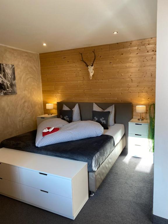a bedroom with a bed with a wooden wall at Haus Alpenglühen in Ehrwald