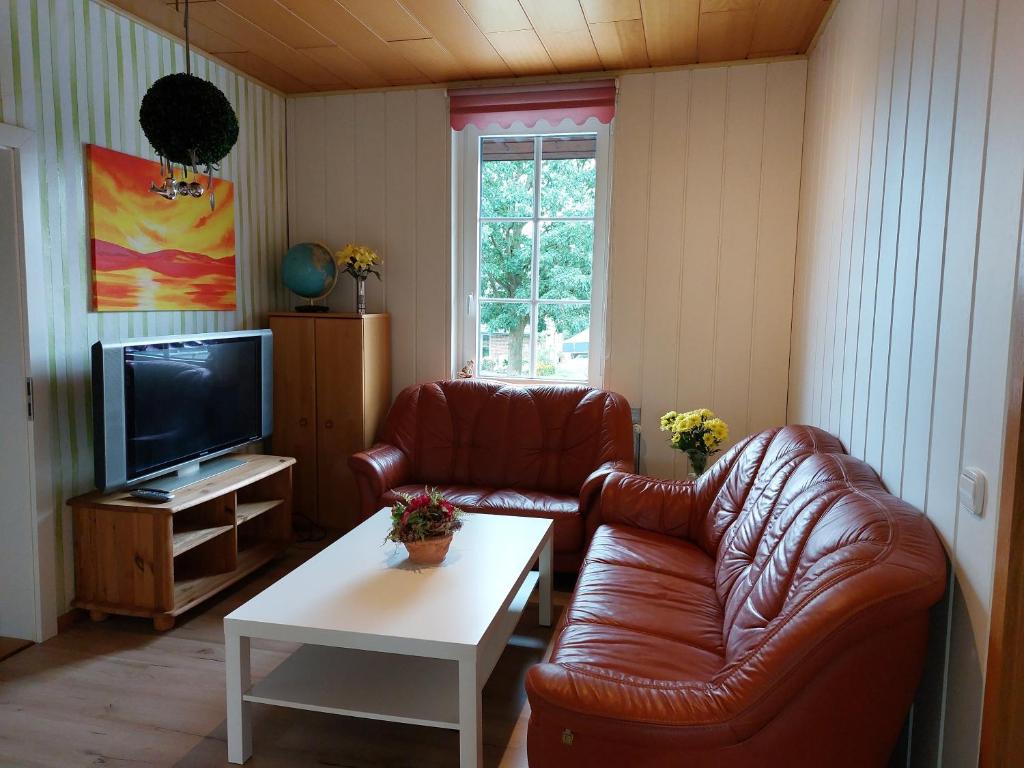 a living room with two leather chairs and a television at Ferienwohnung am Drömling Südheide - Kurt in Bergfeld